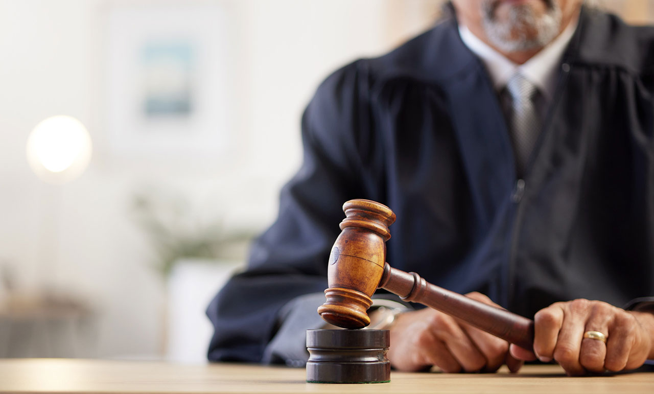 Judge holding a gavel in court, illustrating malicious wounding as a violent felony in Virginia
